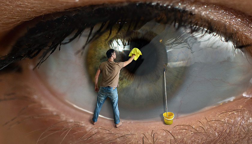 Cataratta. Operaio maschio che pulisce la superficie della pupilla dell'occhio con uno straccio. Concetto di vista sana, congiuntivite e pulizia delle finestre.