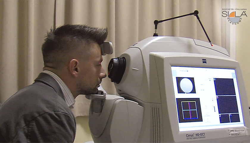 Ragazzo in studio oculistico vicino allo strumento per l'esame OCT per il glaucoma